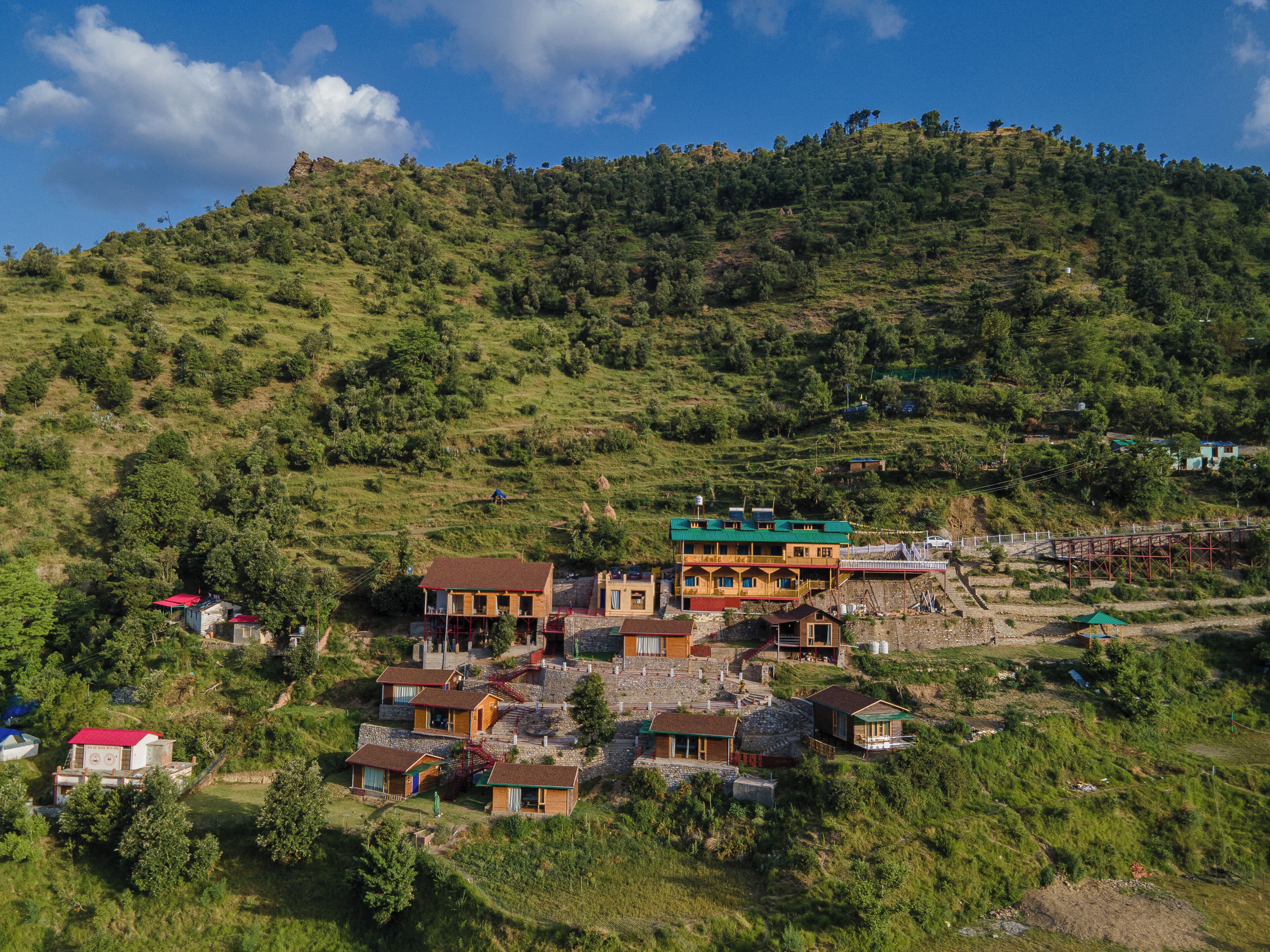 A hillside village with traditional houses, a bridge, and a hilltop viewpoint.