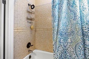 Bathtub, hair dryer, towels, shampoo