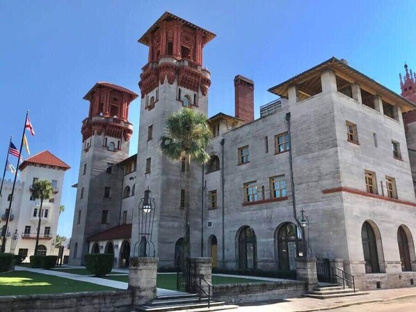 A large, historic building with a central tower, arched windows, and a symmetrical facade.