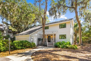 A two-story house with a porch, surrounded by mature trees and well-maintained landscaping. - New Reno! Seabrook amenities and beach access (Seabrook Island)