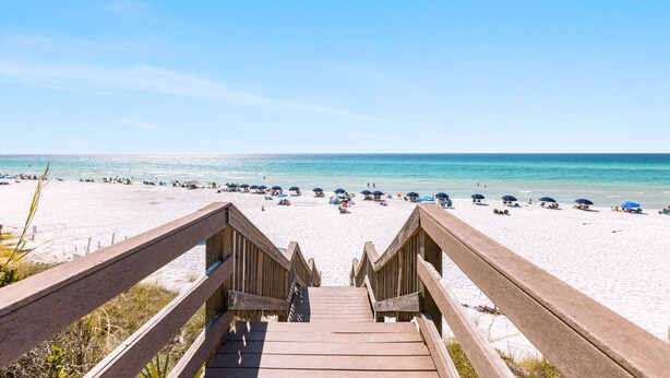 A wooden boardwalk leading to a beach with umbrellas and people. - Views of the Gulf, Private Beach Access, & Bikes (Santa Rosa Beach)