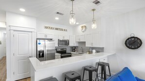 A modern kitchen with white cabinetry, stainless steel appliances, and a central island. - Views of the Gulf, Private Beach Access, & Bikes (Santa Rosa Beach)