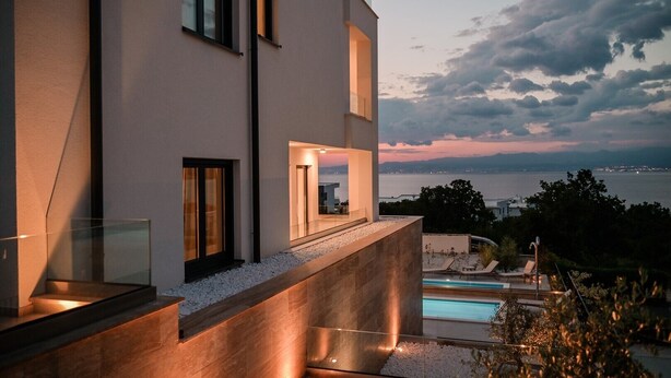 A modern building with a pool and a view of the sea.