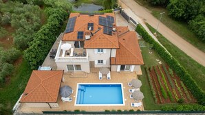 A two-story house with a swimming pool, solar panels, and a garden. - Lovely Villa Buroli with swimming pool, jacuzzi and sauna (Buroli)