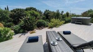 A rooftop terrace with lounge chairs, a table with cups, and a small building. - Spacious villa with pool, hot tub and large garden (Montinhos Da Luz)