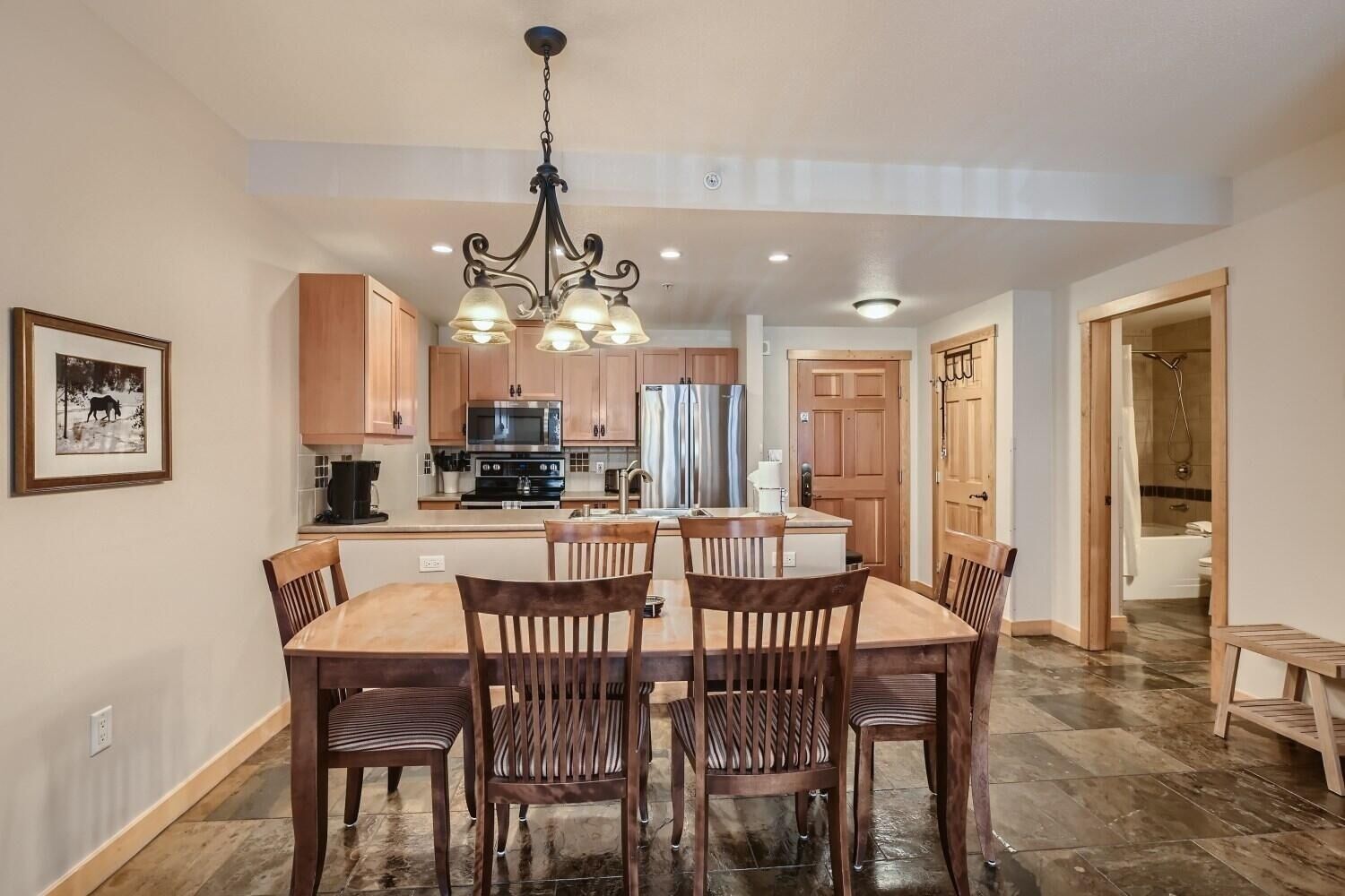 A spacious kitchen with wooden cabinets, a central island, and a dining area with four chairs.