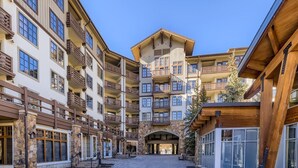 Un hotel de varios pisos con balcones, fachada de piedra y un patio adoquinado.
