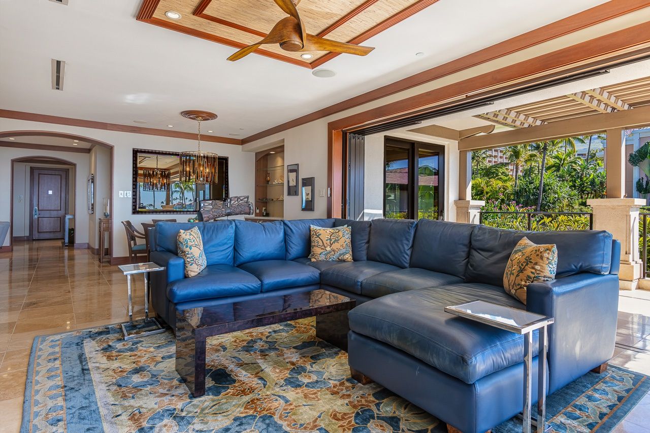 A spacious living area with a large sectional sofa, a coffee table, and a patterned rug.