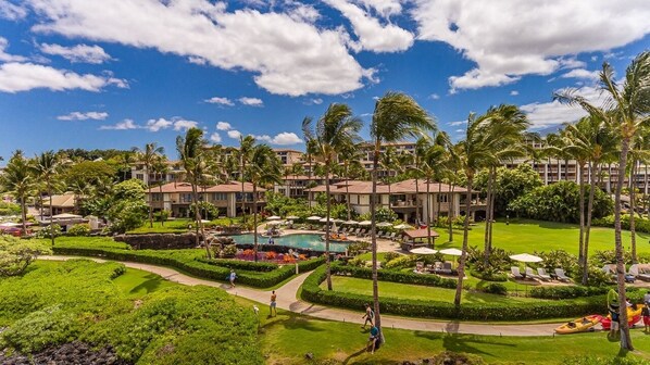 A resort with multiple buildings, a swimming pool, and well-maintained lawns.