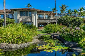 A resort with a pool, lush greenery, and a large building with multiple windows. - Wailea Beach Villa B202 3 Bedroom Condo (Kihei)