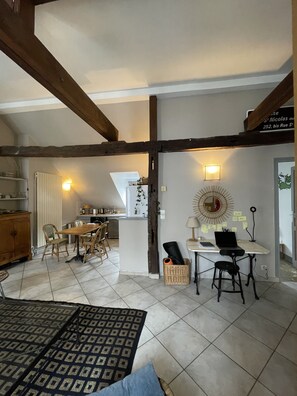 Cozy dining area with a wooden table and chairs, kitchenette, and office space.