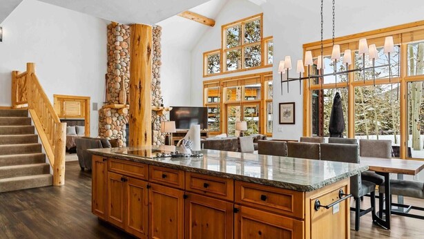 A spacious kitchen with a large island, wooden cabinets, and a stone accent wall.