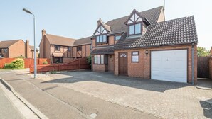 Ein Wohnhaus mit Garage, befestigter Auffahrt und einer Straßenlaterne.
