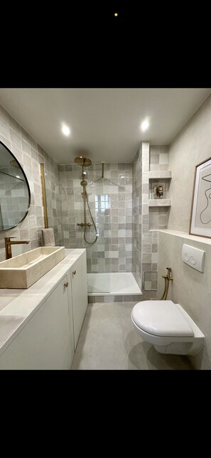 Een douche, een haardroger, een bidet, handdoeken