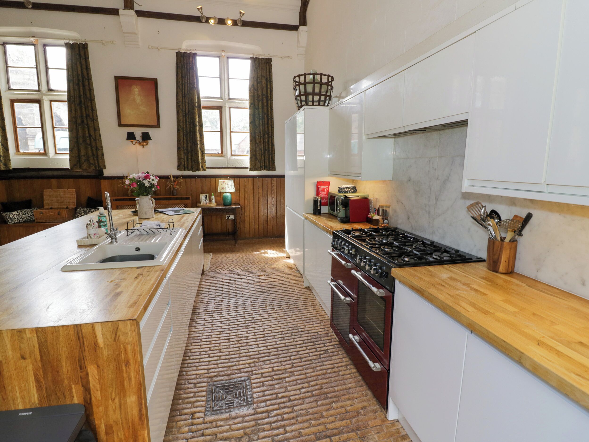 Una cocina con encimera de madera, estufa y pileta.