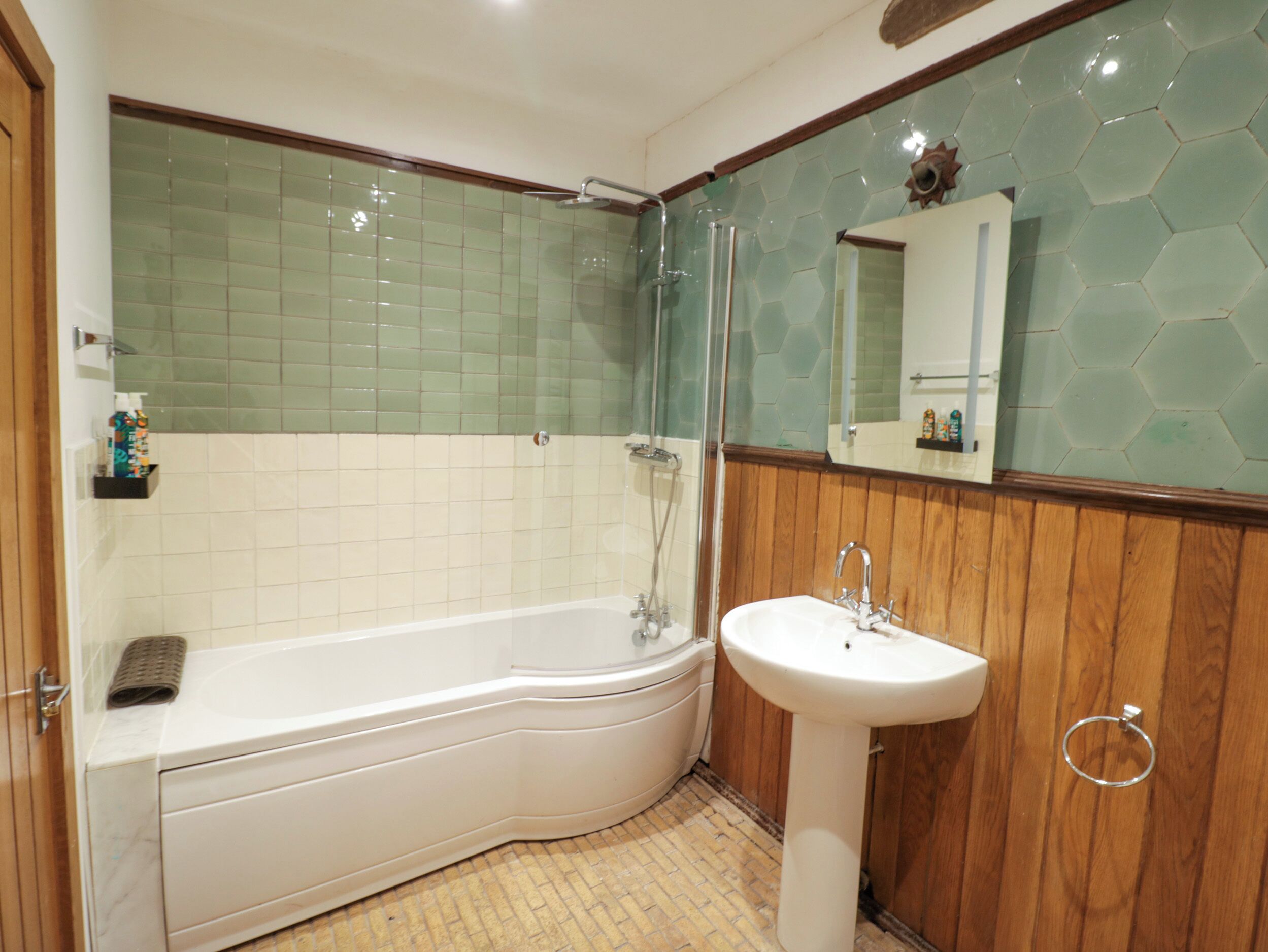 Ein Badezimmer mit einer weißen Badewanne, einem Waschbecken und einer Dusche.