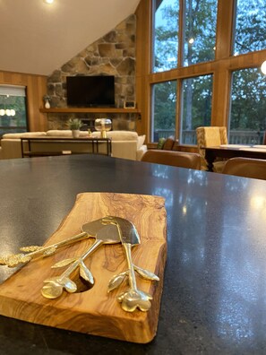 Una cocina con pared de piedra, una isla grande y una zona de comedor con sillas.
