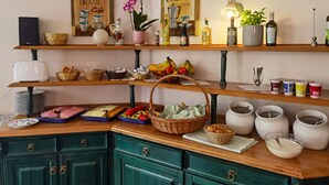 Eine Küche mit Holzböden, die Geschirr, eine Kaffeemaschine und ein Orchideenbild zeigen.