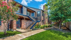 A two-story building with a brick facade, a central staircase, and a well-maintained lawn. - Cozy Medical Center Retreat in San Antonio (San Antonio)