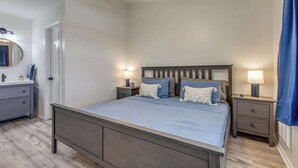 A bedroom with a bed, bedside tables, a mirror, and a ceiling fan. - Cozy Medical Center Retreat in San Antonio (San Antonio)