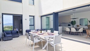 Un comedor moderno con una mesa grande dispuesta para seis personas, rodeada de sillas blancas.