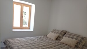 Une chambre à coucher avec un lit, une fenêtre et une vue sur la verdure.