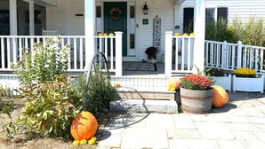 A house with a porch, a welcome sign, and decorative pumpkins.