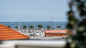 Un port de plaisance avec des bateaux amarrés, un pont en arrière-plan et un ciel dégagé.