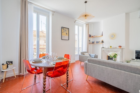 A dining area with a round table, red chairs, and a chandelier. - Elana - Bel appartement dans la quartier du Camas (Marseille)
