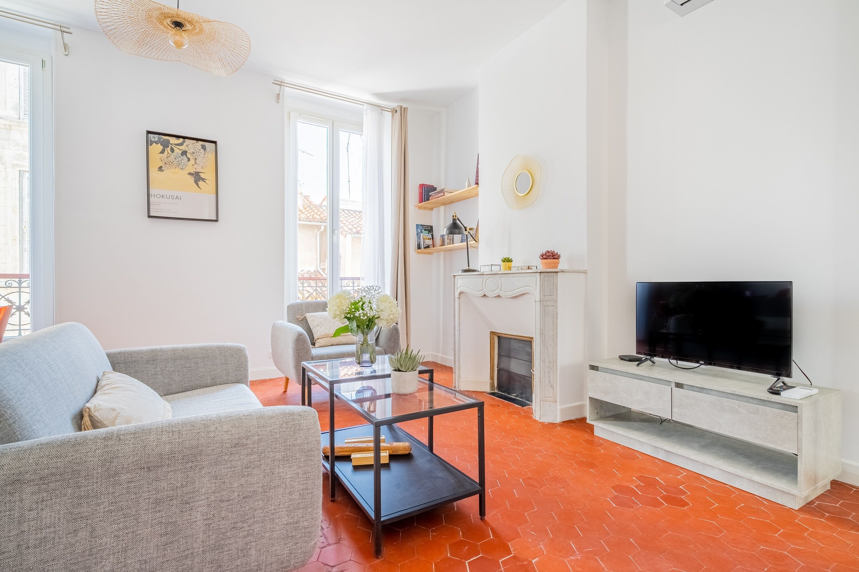 A living room with a sofa, a glass coffee table, a fireplace, and a television.