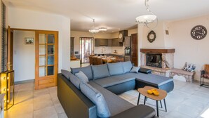 Una sala moderna con un sofá seccional, una mesa de comedor y una chimenea.