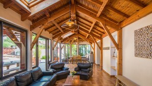 Amplia sala de estar con vigas de madera, sofás de cuero y una mesa de centro.