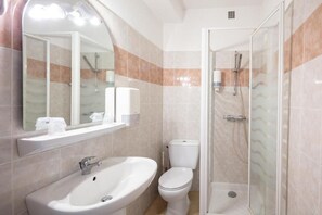 A bathroom with a sink, toilet, and glass-enclosed shower.