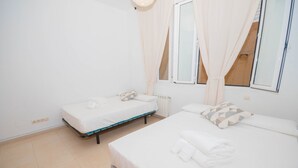 A clean, modern bedroom with two beds, a large window with curtains, and a view of the outside. - Rooms for rent in Barrio Chueca - Madrid INF1F (Madrid)