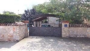 A gated entrance with a stone wall and a metal gate.