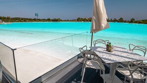 Een terras met een tafel en stoelen met uitzicht op een turquoise oceaan.