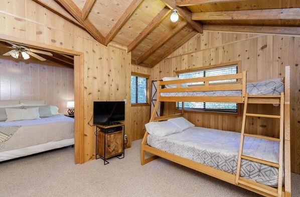 A wooden cabin room with bunk beds, a television, and a small cabinet. - Cozy Chalet in the Woods
http://www.innsbrook-resort.com/ (Innsbrook)