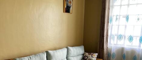 A cozy living room with a wooden sofa set, a small wooden table, and a patterned rug.