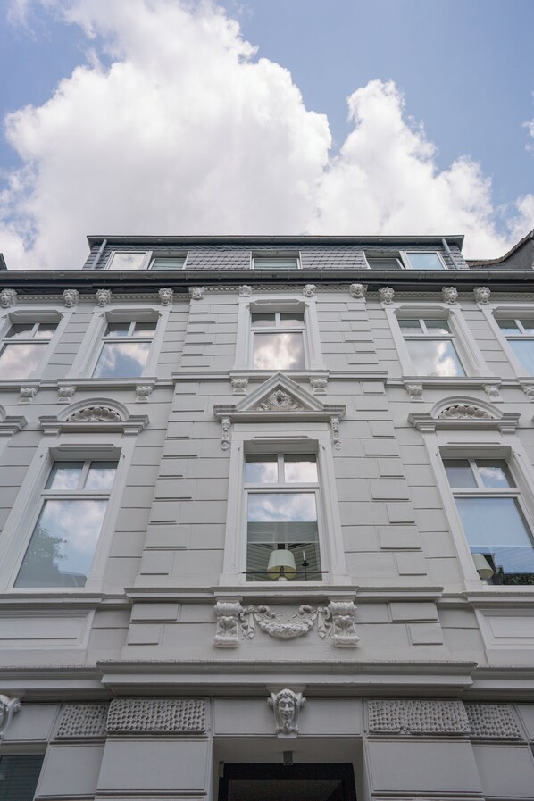 Ein Gebäude mit klassischer Architektur, gekennzeichnet durch symmetrische Fenster und dekorative Stuckleisten.