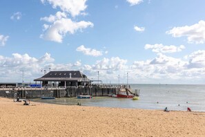 Een strand met een pier, een bewakingspost en een zandstrand.