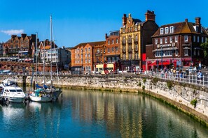 A waterfront area with historic buildings, a marina with boats, and a stone wall. - Ramsgate | Elegant Georgian Home | Harbour | Beach (Kent)