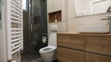 Apartamento família | Banheiro | Chuveiro, secador de cabelo, toalhas de banho, papel higiênico