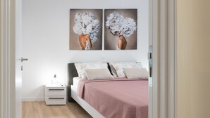 Une chambre à coucher avec un lit, des tables de chevet et une œuvre d’art accrochée au mur.