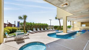 A pool area with multiple pools, lounge chairs, and a covered seating area.
