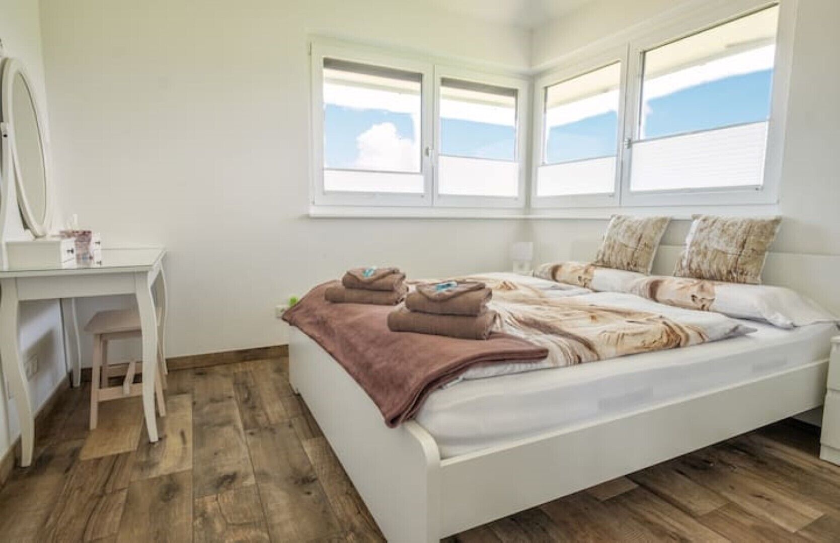 Un dormitorio con cama, escritorio y ventana.