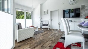 Una sala de estar moderna con un sofá, una mesa de centro y un comedor con una mesa y sillas.