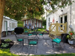 A patio with outdoor furniture, a barbecue grill, and a wooden deck. - Spacious yet cozy, newly remodeled home steps away from the Surf Ballroom. (Clear Lake)