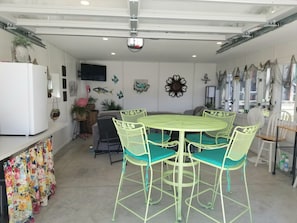 A kitchen with a round table, four chairs, a refrigerator, and various wall decorations. - Spacious yet cozy, newly remodeled home steps away from the Surf Ballroom. (Clear Lake)