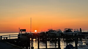 A marina at sunset with boats docked and a clear sky.