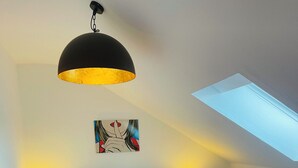 Un dormitorio moderno con una cama grande, un tragaluz y dos lámparas de noche.